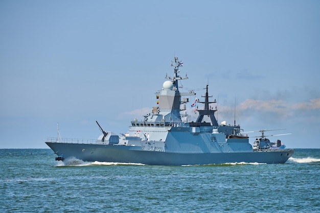 Corbeta de buque de guerra acorazado con helicóptero en cubierta realizando ejercicios militares en el Mar Báltico. Barco de guerra con helicóptero navegando en el hermoso mar azul. Buque de guerra militar, Armada rusa