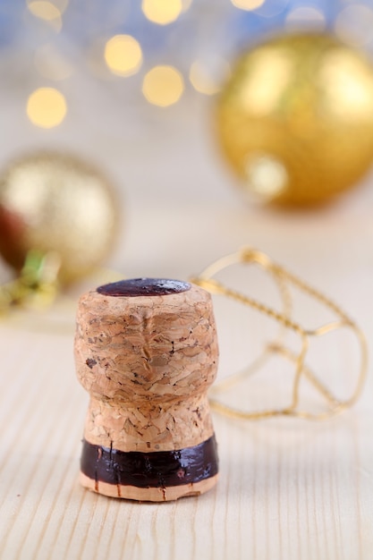 Corcho de champán sobre fondo de luces de Navidad