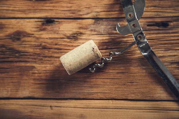 Corcho de vino y sacacorchos en la mesa de madera