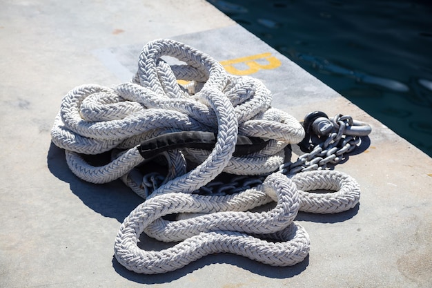 Corda branca de amarração no cais da marina de iates de luxo