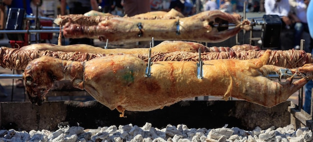 Cordeiros inteiros e kokorec no fogo de brasas