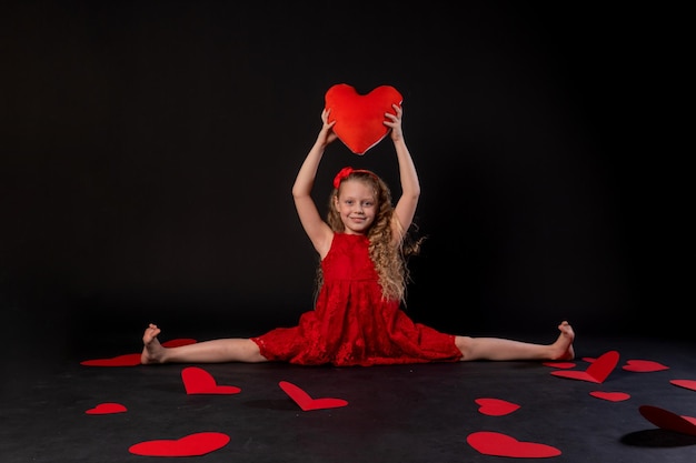 En cordel en las manos del corazón corazones de papel diseño rojo en el suelo corazones encantador romance inspiración copia espacio sentirse negro en rojo vestido de niña descalzo