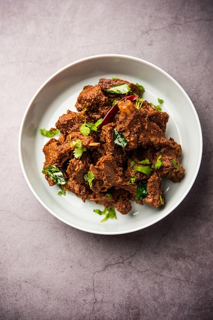 Cordero Sukha o carne seca de pollo picante Murgh o carne de cabra servida en un plato o tazón