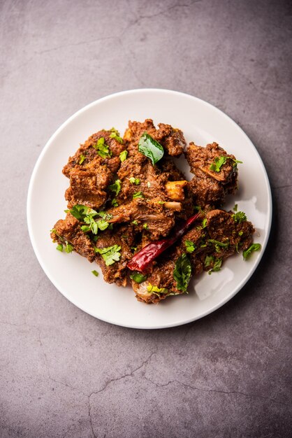 Cordero Sukha o carne seca de pollo picante Murgh o carne de cabra servida en un plato o tazón