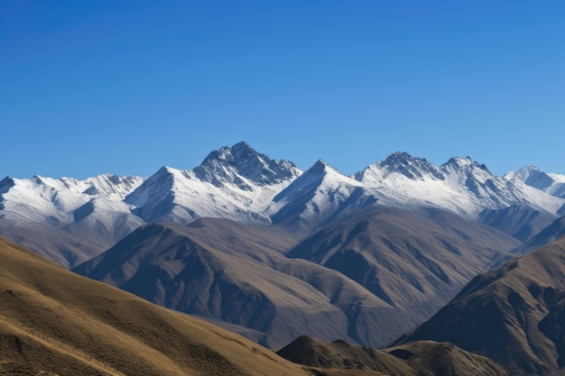 Cordilheira majestosa com picos cobertos de neve e céu azul claro criado com IA generativa