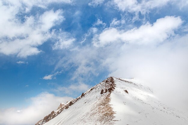 Cordilheira nevada com fundo de céu azul com espaço de cópia