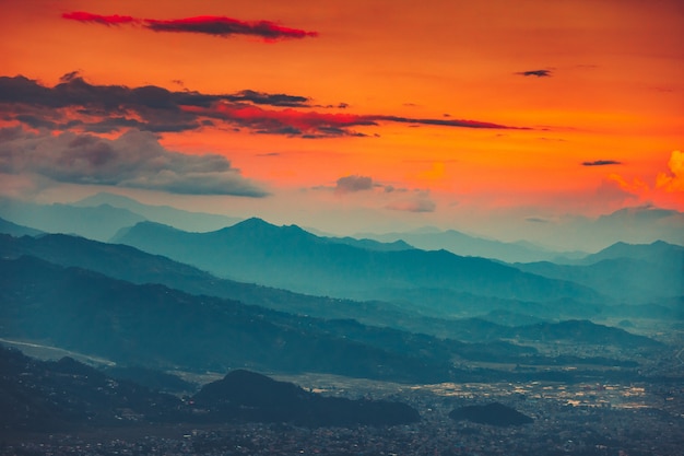 Cordillera azul y naranja atardecer cielo nublado