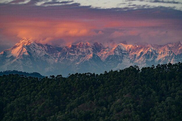 Foto una cordillera con una puesta de sol rosa en el fondo