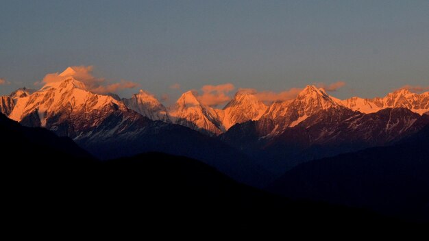 una cordillera con el sol poniéndose detrás de ella