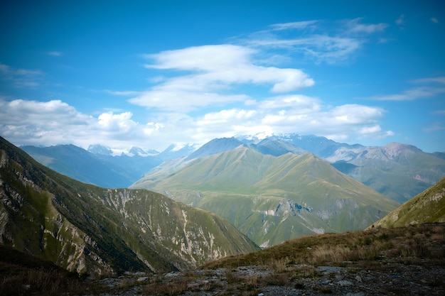 Foto cordilleras en un día soleado en georgia sky con nubes y colinas