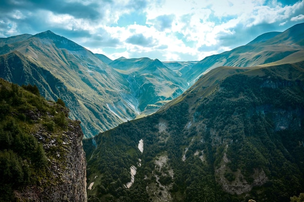 Foto cordilleras en un día soleado en georgia sky con nubes y colinas