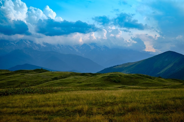 Foto cordilleras en un día soleado en georgia sky con nubes y colinas