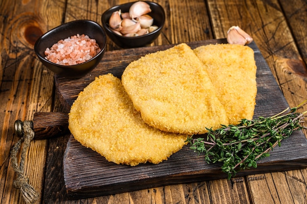 Cordon Bleu Fleischkoteletts mit Semmelbröseln auf einem Holzbrett