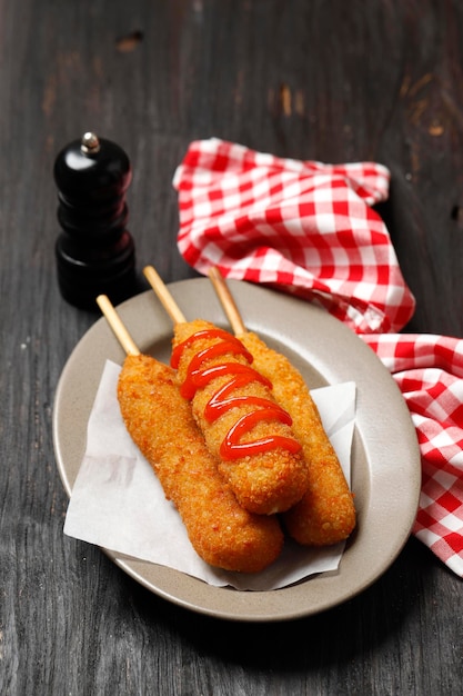 Corn dog é uma salsicha no palito com queijo mussarela, revestida com massa de farinha e frita. comida de rua coreana de cachorro-quente