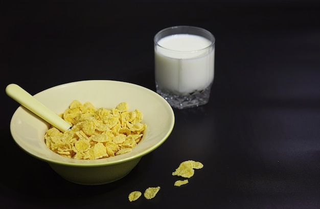 Cornflakes in einem Teller. Frühstück aus Flocken mit Honig und Milch. Schnelles Frühstück mit Cornflakes