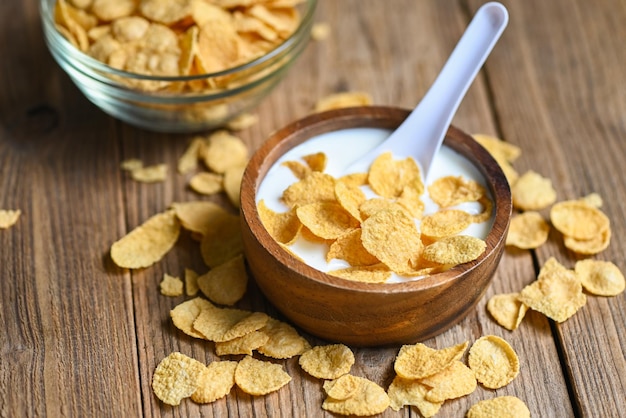 Cornflakes-Schüssel-Frühstück und Snack für ein gesundes Ernährungskonzept Morgenfrühstück frische Vollkorngetreide-Cornflakes mit Milch auf Tischlebensmittelhintergrund