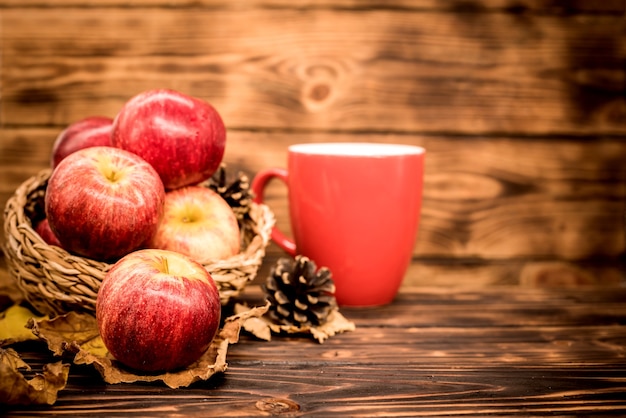 Cornucopia de la cosecha de otoño. Taza de té de manzana caliente para la bebida caliente de la temporada de otoño. Copie el espacio sobre fondo de madera.