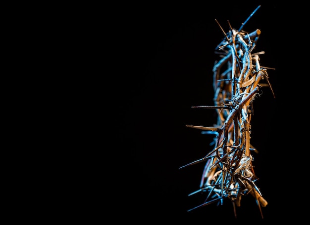 Coroa de espinhos com tonalidade azulada no escuro. O conceito de Semana Santa, sofrimento e crucificação de Jesus.