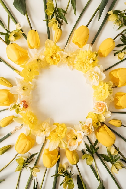 Coroa de flores com moldura redonda feita de narciso amarelo e flores de tulipa em branco