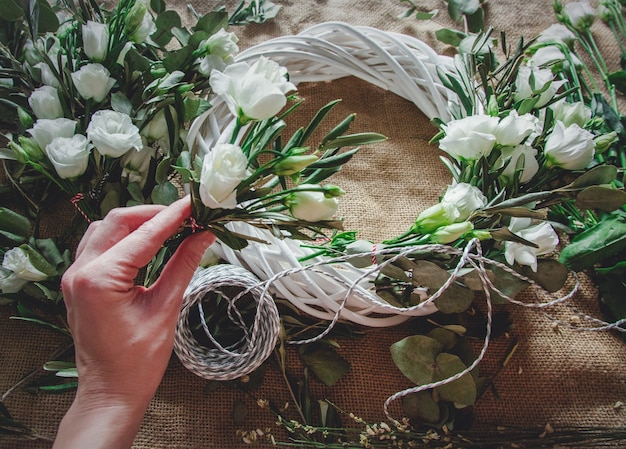 Coroa de flores com rosas brancas em fundo de juta. Decorado