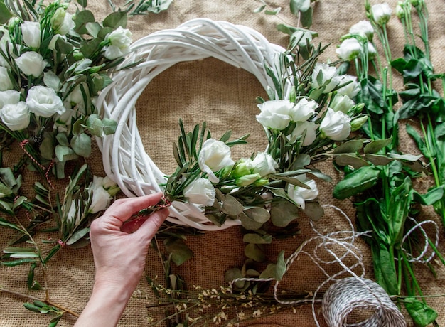 Coroa de flores com rosas brancas em fundo de juta. Decorado