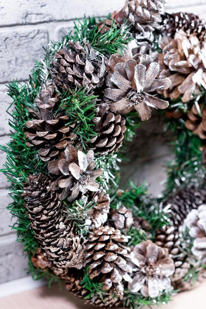 Coroa de Natal feita de ramos de abeto e cones naturais Contra o fundo de uma parede de tijolos cinza Ano Novo e férias de inverno Decoração de Natal