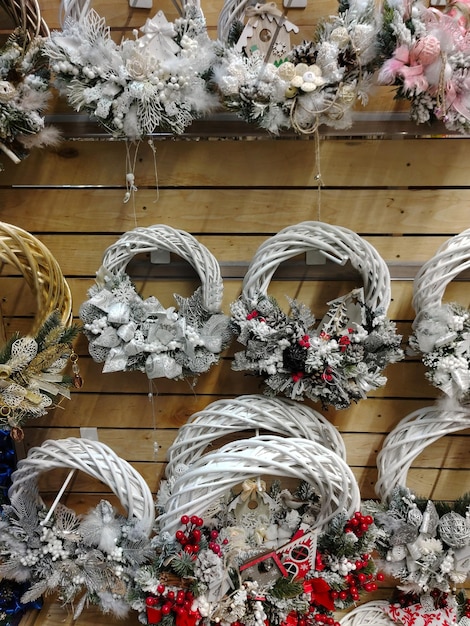 Coroas de vime de Natal de várias formas penduradas em fileiras em uma loja para venda