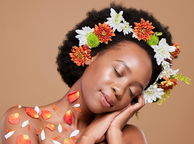 Corona de flores y mujer negra se relajan en el estudio para el cuidado de la piel de belleza y productos vegetales sobre fondo marrón Naturaleza flores y piel de mujer y modelo de bienestar feliz calma y lujo orgánico y facial