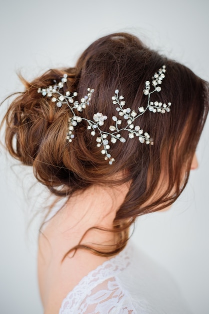 Corona de flores de plata en el cabello oscuro de una novia