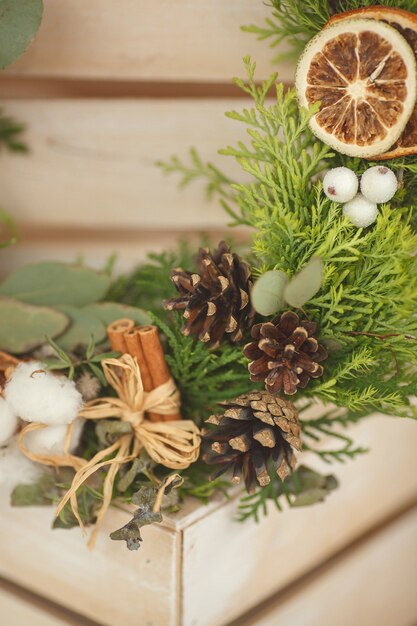 Corona de Navidad con canela y conos y naranjas secas con ramitas de abeto.