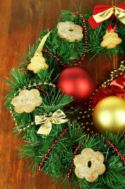 Corona de Navidad decorada con galletas sobre fondo de madera