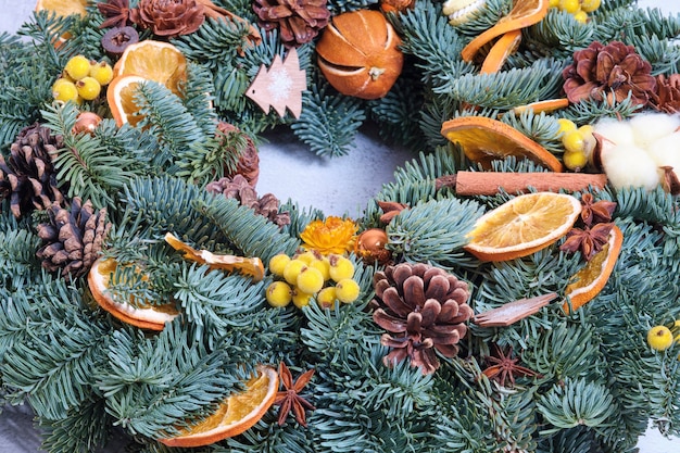 La corona de Navidad está decorada con flores y frutos secos.