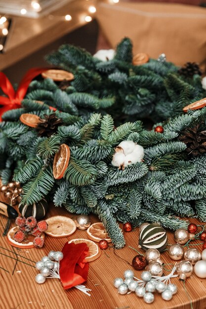 Corona de Navidad hecha a mano está sobre la mesa con otras decoraciones navideñas.