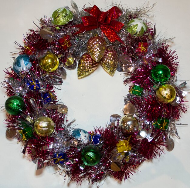Corona de Navidad de oropel conos de abeto decoraciones de año nuevo aislado fondo blanco.
