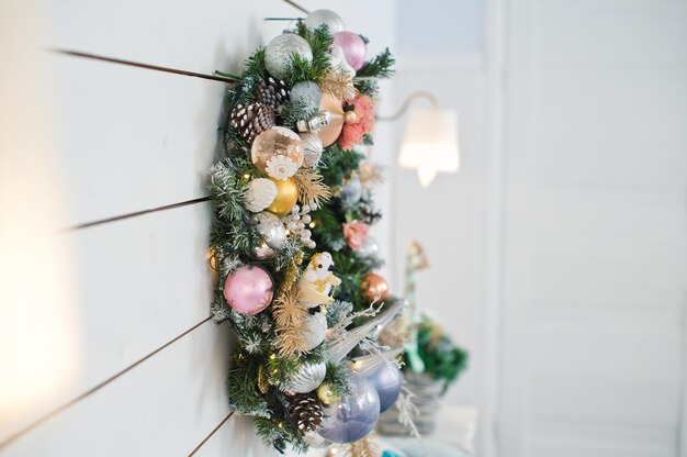 Corona de Navidad en la pared de madera blanca, decoración de la cama.