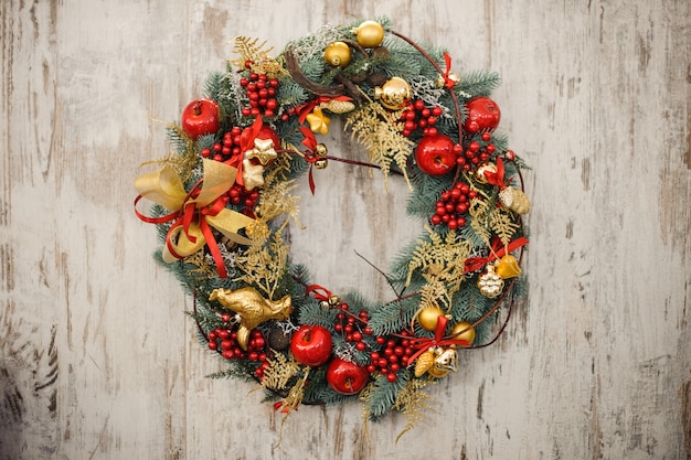 Corona de Navidad en una puerta de madera rústica.