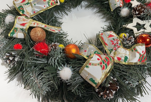 Corona de Navidad que decora la puerta principal para las vacaciones hecha de estrellas de arcos de plata de abeto