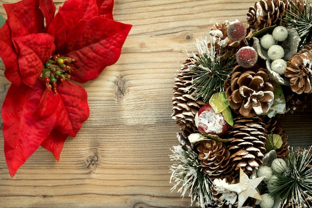 Corona de Navidad y rama con flores rojas