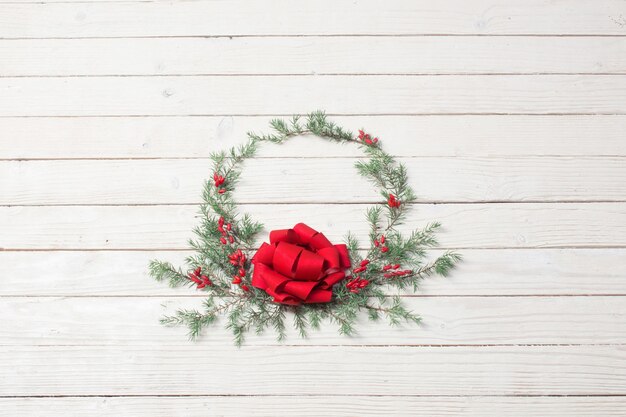 Corona de Navidad sobre superficie de madera blanca