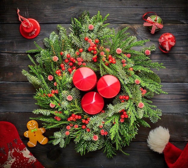 Corona de Navidad y velas sobre fondo de madera