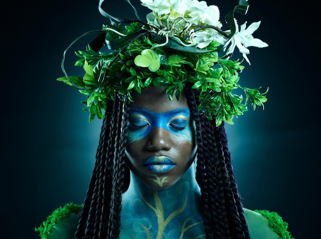 Corona de planta de mujer negra y belleza de cara con maquillaje sobre fondo oscuro con hojas tropicales Persona modelo de hada o Reina de la ecología de la naturaleza y sostenibilidad para el arte de la libertad con corona natural