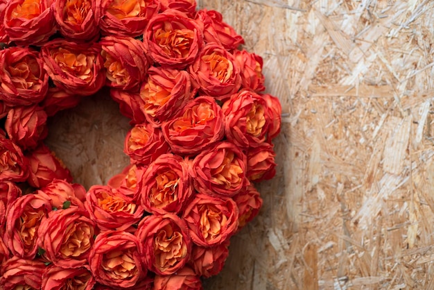 Una corona de rosas se muestra sobre una superficie de madera.