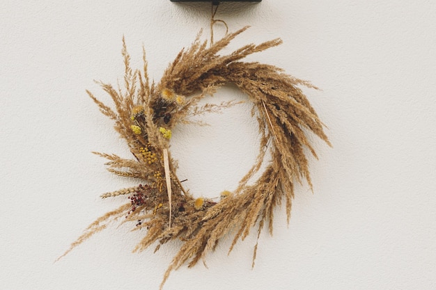 Corona rústica de otoño colgando en la pared en la entrada de la casa Decoración de otoño elegante de la entrada a la granja o al porche Disposición de otoño