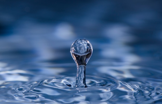 Foto corona de salpicaduras de agua sobre superficie azul