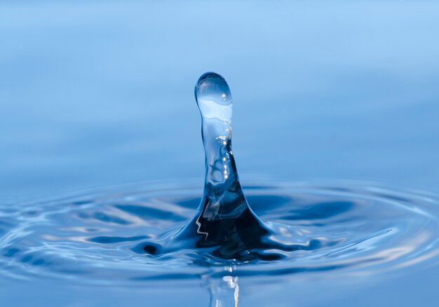 Corona de salpicaduras de agua sobre superficie azul