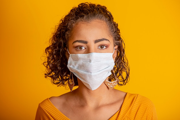 Foto coronavírus (covid-19. jovem mulher que desgasta uma máscara protetora, olhando a câmera, fim acima, isolado. epidemia de gripe, alergia a poeira, proteção contra vírus. conceito de poluição do ar da cidade.