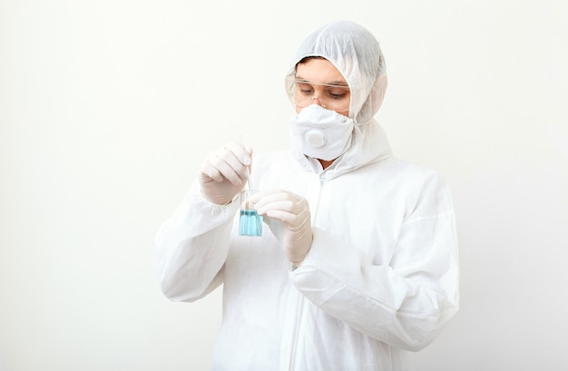 Coronavirus (COVID-19. Médico o científico en traje médico protector, peligro biológico, mascarilla creando vacuna en laboratorio en blanco