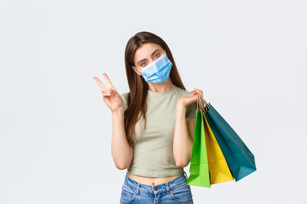 Coronavírus de distanciamento social e conceito de moda de compras boba linda mulher elegante em máscara médica ...