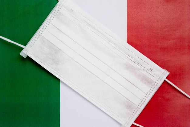 Coronavirus en Italia Máscara médica antibacteriana en el fondo de la bandera italiana
