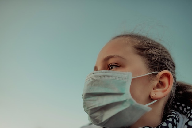 Coronavirus und Luftverschmutzung pm2.5-Konzept.Kleines Mädchen mit Maske zum Schutz von pm2.5.Kindermädchen zu Hause zum Schutz des Corona-Virus inhaftiert.Wuhan-Coronavirus und epidemische Virussymptome.